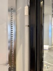Vertical LED light strip on an advertising glass door