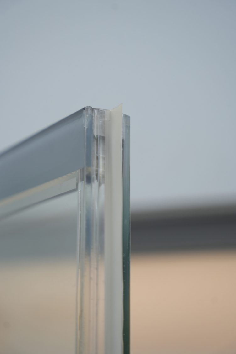 Frameless transparent-spacer glass door edge and shelf detail