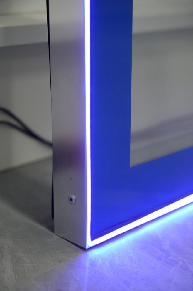 Internal LED light strip detail on a round-corner glass door