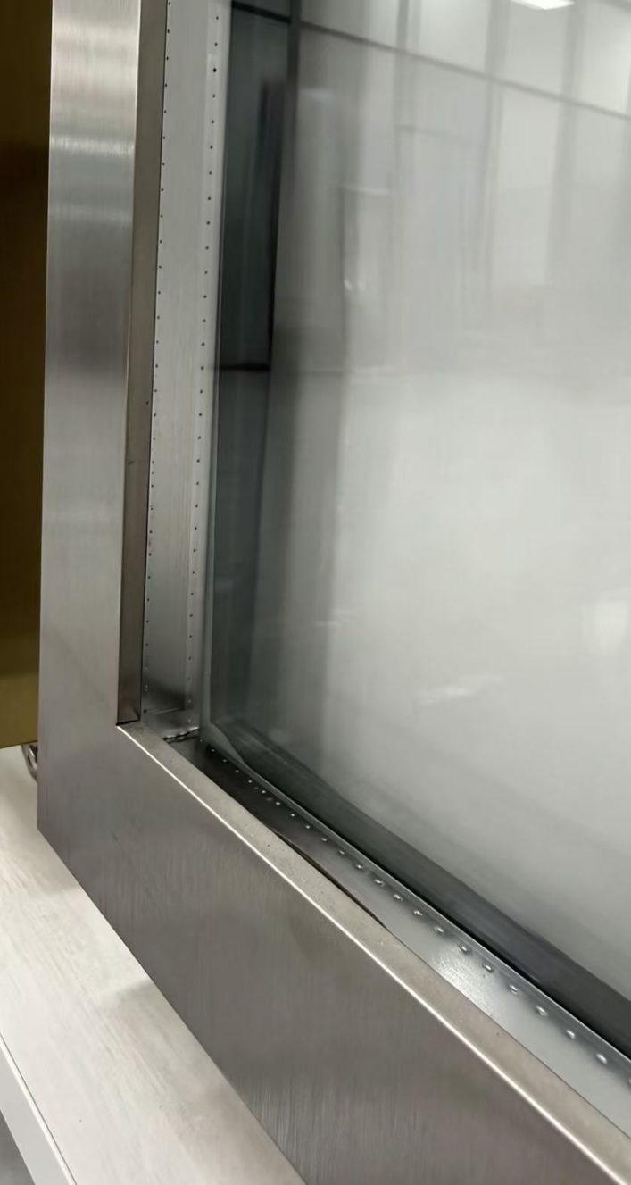 Insulated glass unit edge detail on a stainless steel frame door